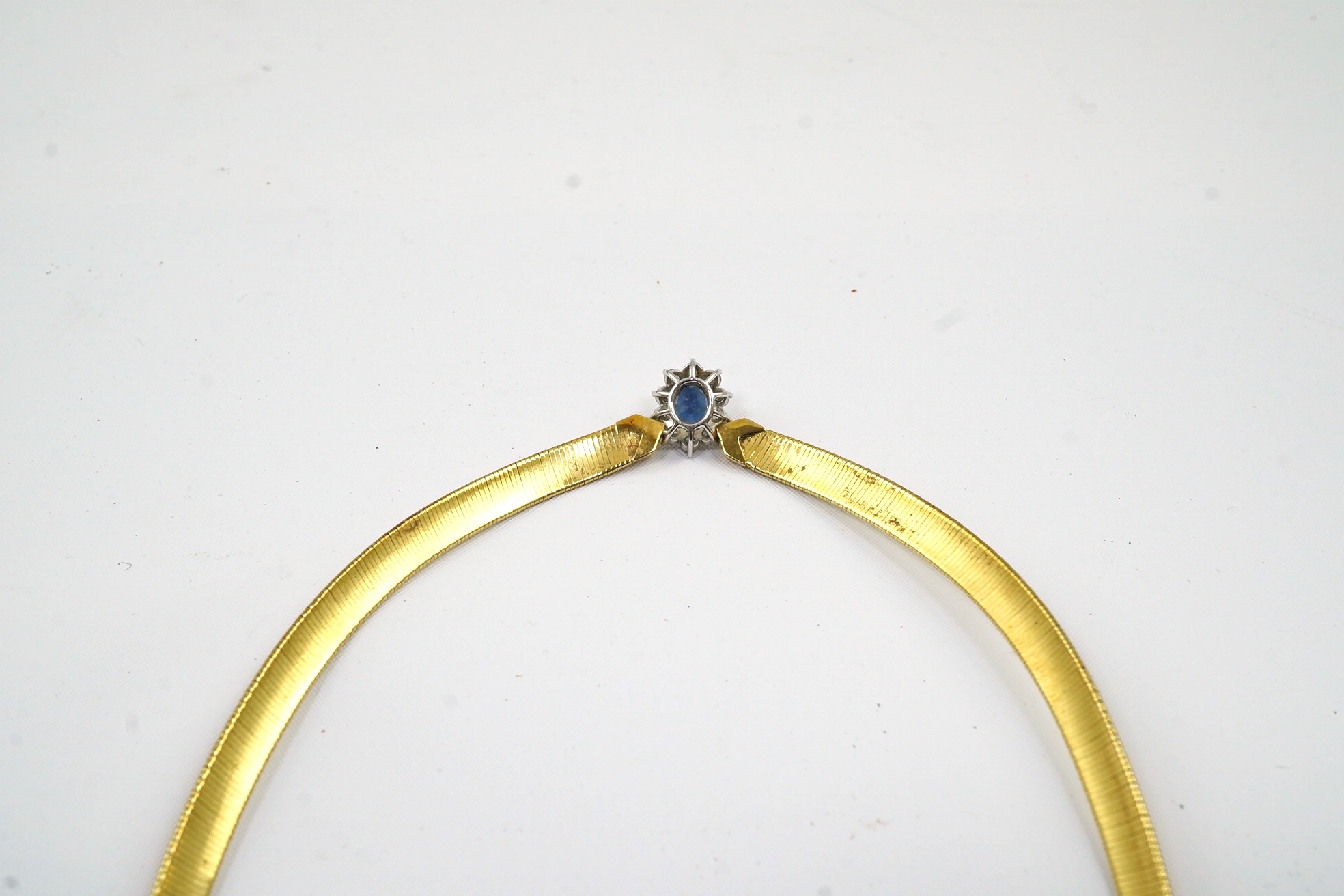 A modern 9ct gold necklet, with central sapphire and diamond set oval cluster